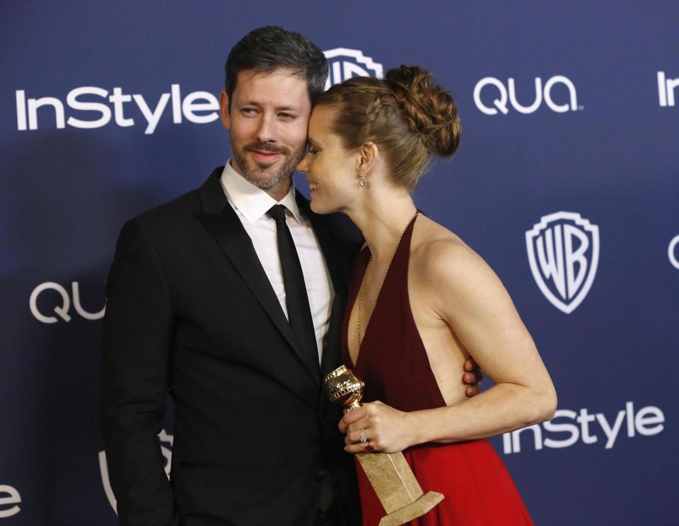 Adams holds award for Best Actress In A Motion Picture, Musical or Comedy for her role in "American Hustle", next to partner Le Gallo at the 15th annual Warner Bros. and InStyle after party in Beverly Hills