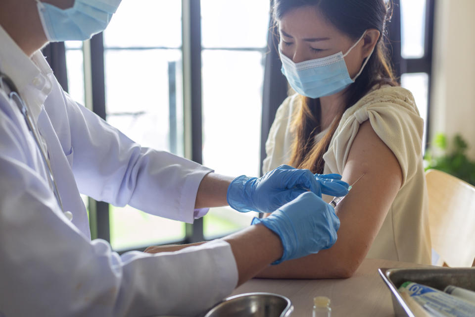 Woman getting a vaccine injection from doctor at hospital. (PHOTO: Getty Images)