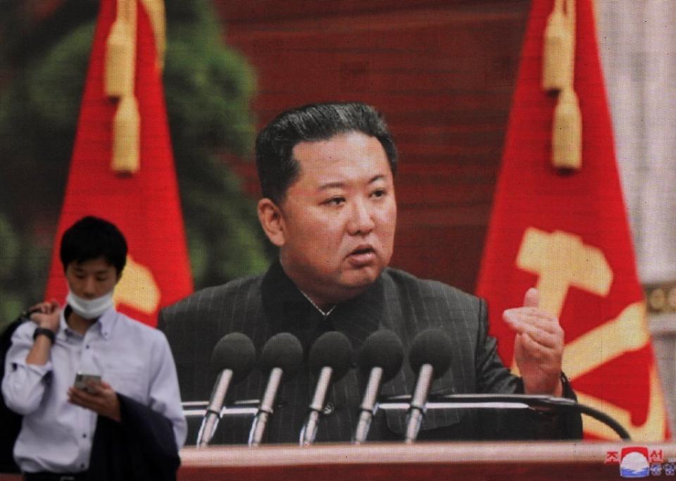 File: A pedestrian walks past a huge screen displaying North Korean leader Kim Jong-un  (EPA)