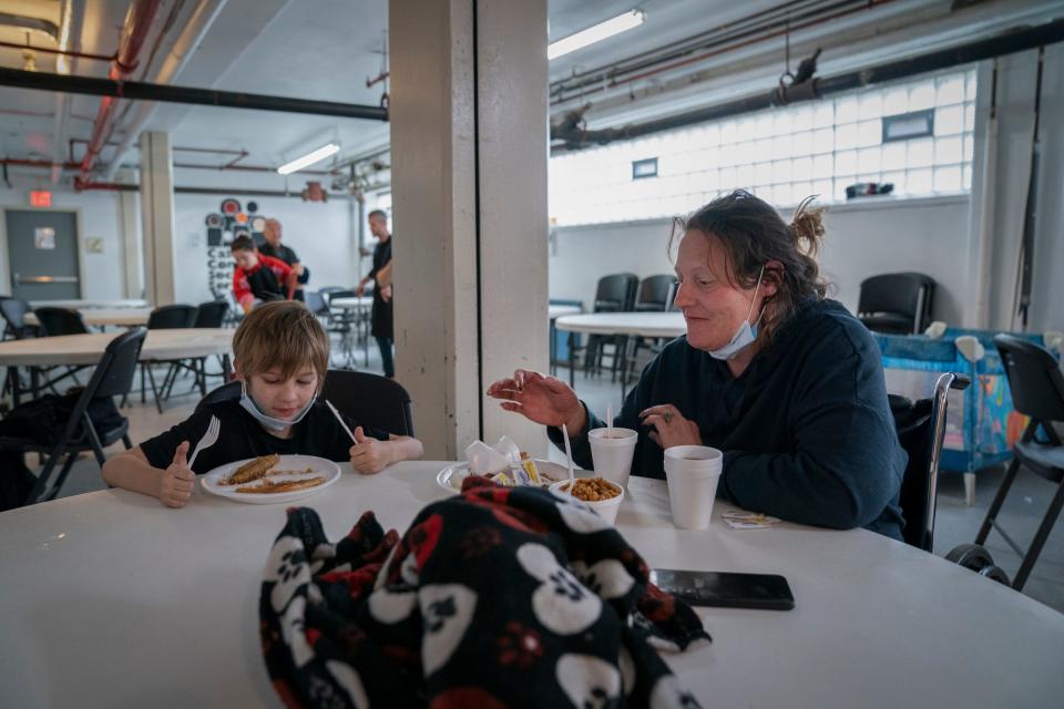 Cash Howse, 8, eats breakfast with his mom Tiffany Potter, 42, at the Cass Community Social Services in Detroit on Monday, Dec. 25, 2023, as Mitzvah Day volunteers clean up the dining area. Volunteers from the Jewish and interfaith community volunteer to give the day off to employees so they can be home for Christmas. "We are thankful and grateful," said Potter.