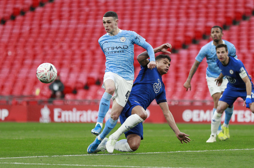 Manchester City's Phil Foden, left, challenges for the ball with Chelsea's Thiago Silva during the English FA Cup semifinal soccer match between Chelsea and Manchester City at Wembley Stadium in London, England, Saturday, April 17, 2021. (AP Photo/Ian Walton, Pool)