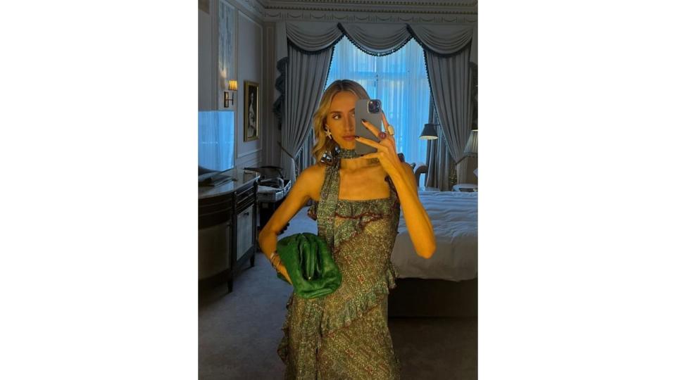 Mia Southgate posing inside a hotel home in a green bejewelled dress