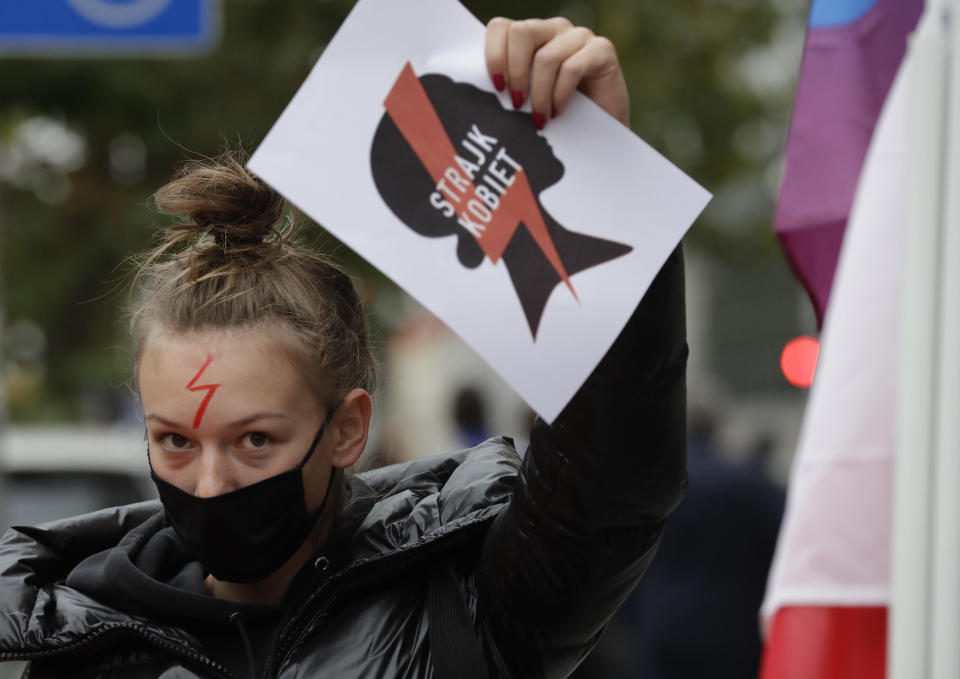 A women's rights activist with a poster of the Women's Strike action protests in Warsaw, Poland, Wednesday, Oct. 28, 2020 against recent tightening of Poland's restrictive abortion law.  / Credit: Czarek Sokolowski / AP