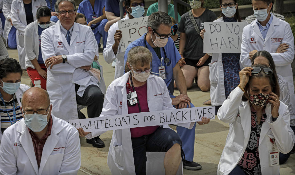 FILE - This photo from Friday June 5, 2020, shows physicians and other healthcare workers as they pause for 8 minutes 46 seconds of silence for George Floyd, in a White Coats for Black Lives protest in Salt Lake City. The chaos unleashed in 2020, amid the coronavirus pandemic, has created space for different voices to speak, for different conversations to be had and for different questions to be asked. (AP Photo/Rick Bowmer, File)