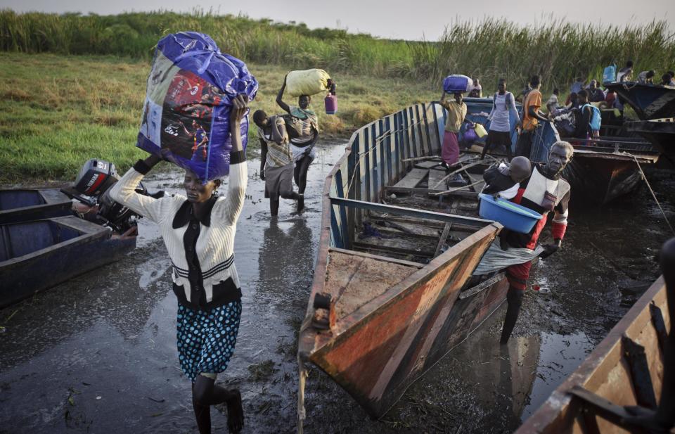 In this photo taken Thursday, Jan. 2, 2014, displaced people arrive with what belongings they had time to gather by river barge from Bor, some of the thousands who fled the recent fighting between government and rebel forces in Bor by boat across the White Nile, in the town of Awerial, South Sudan. (AP Photo/Ben Curtis)