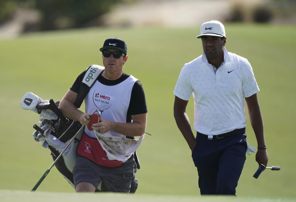 Tony Finau, of the United States, right, and his caddie Ryan Smith, owner of the Utah Jazz and co-founder software firm Qualtrics, enter the third green during the second round of the Hero World Challenge PGA Tour at the Albany Golf Club, in New Providence, Bahamas, Friday, Dec. 3, 2021.(AP Photo/Fernando Llano)