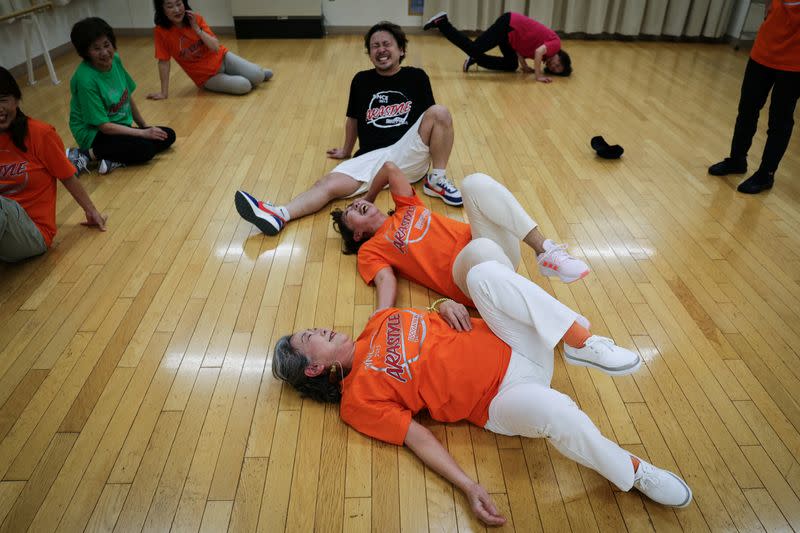 Yusuke Arai (atrás), de 38 años, instructor del único club de breakdance de Japón formado por personas mayores Ara Style Senior, entrena a Saruwaka Kiyoshie (delante), de 74 años, y a Reiko Maruyama, de 71, mientras practican un movimiento de baile durante una sesión de entrenamiento en Tokio, Japón