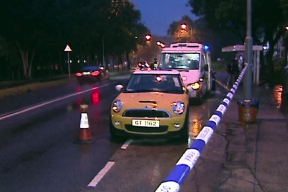 This May 22, 2015, image from video provided by Now TV shows a yellow mini cooper where the suspect's wife and daughter were found unconscious in Hong Kong. An anesthesiologist is on trial in Hong Kong charged with killing his wife and daughter by placing a leaking yoga ball filled with carbon monoxide in their car. (Now TV via AP)