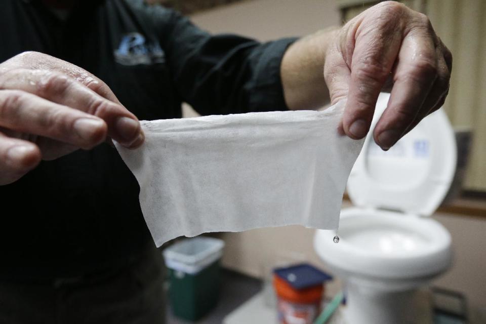 In this photograph taken, Friday, Sept. 20, 2013, in Middlesex, N.J., Rob Villee, executive director of the Plainfield Area Regional Sewer Authority in New Jersey, holds up a wipe he flushed through his test toilet in his office. Increasingly popular bathroom wipes, thick, premoistened towelettes that are advertised as flushable, are creating clogs and backups in sewer systems around the nation. The problem has gotten so bad in this upstate New York town that frustrated sewer officials traced the wipes back to specific neighborhoods, and even knocked on doors to break the embarrassing news to residents that they are the source of a costly, unmentionable mess. An industry trade group this month revised its guidelines on which wipes can be flushed, and has come out with a universal stick-figure, do-not-flush symbol to put on packaging. (AP Photo/Julio Cortez)