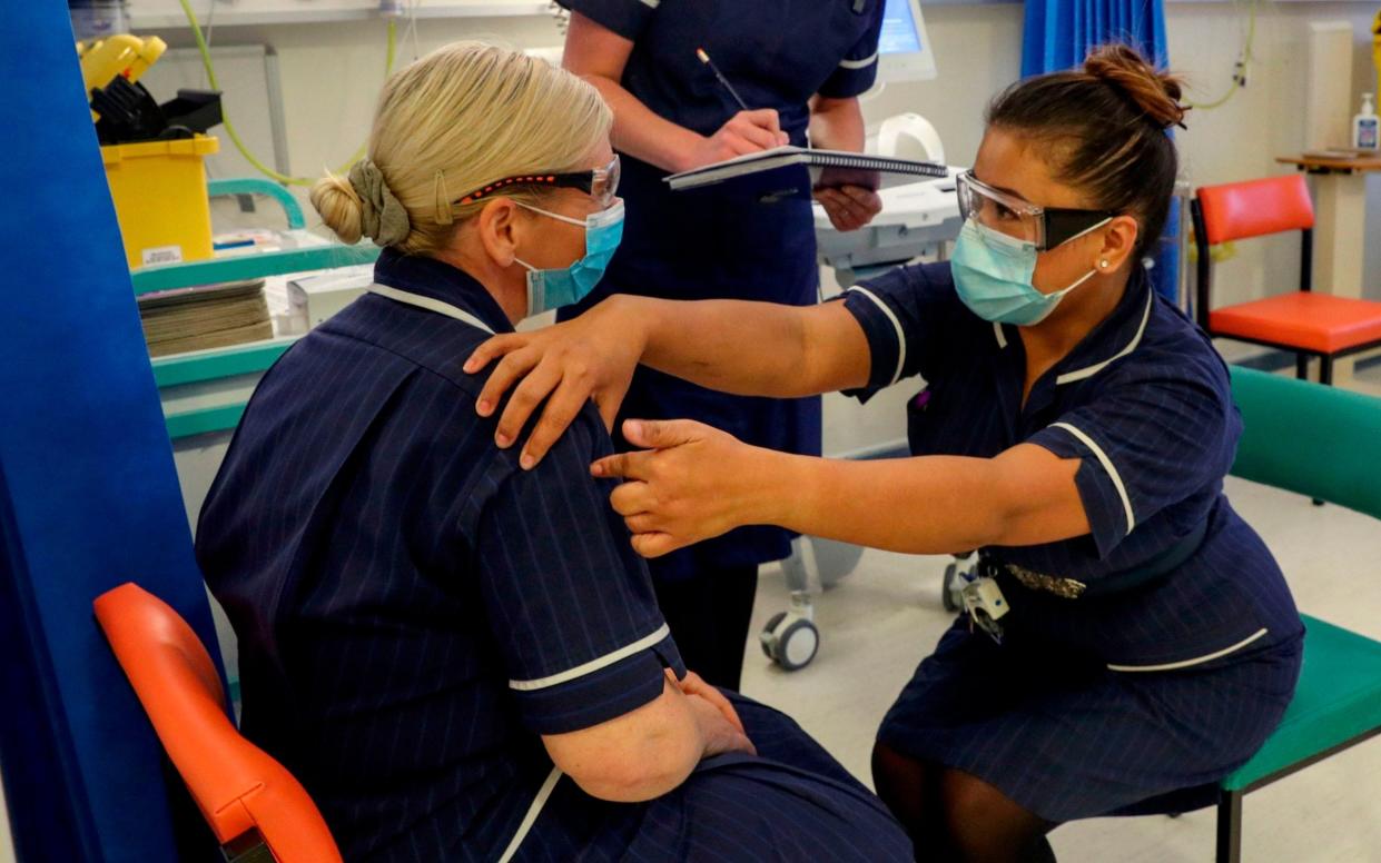 Matron May Parsons, right, talks to Heather Price during training in the coronavirus vaccination clinic at University Hospital in Coventry on Friday prior to the NHS administering jabs to the most vulnerable early next week - Steve Parsons/AFP