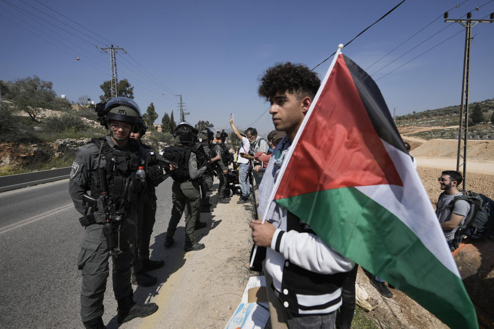 Israeli border police officers block hundreds of Israeli left-wing activists from staging a solidarity rally in the Palestinian town that was set ablaze by radical Jewish settlers earlier this week, next to the West Bank town of Hawara, Friday, March 3, 2023. On Monday scores of Israeli settlers have gone on a violent rampage in the northern West Bank town of Hawara, setting cars and homes on fire after two settlers were killed by a Palestinian gunman. (AP Photo/Majdi Mohammed)