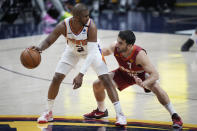 Phoenix Suns guard Chris Paul, left, looks to pass the ball as Denver Nuggets guard Facundo Campazzo defends in the second half of Game 4 of an NBA second-round playoff series, Sunday, June 13, 2021, in Denver. (AP Photo/David Zalubowski)