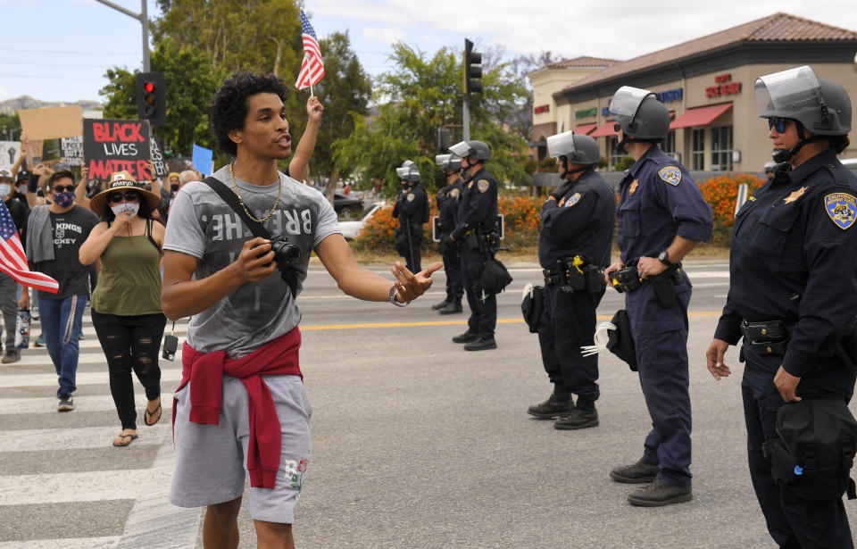 A demonstrator thanks California Highway Patrol officers as they block the entrance to a freeway during a protest, Saturday, June 6, 2020, in Simi Valley, Calif., over the death of George Floyd. Floyd died after he was restrained in police custody on Memorial Day in Minneapolis. (AP Photo/Mark J. Terrill)