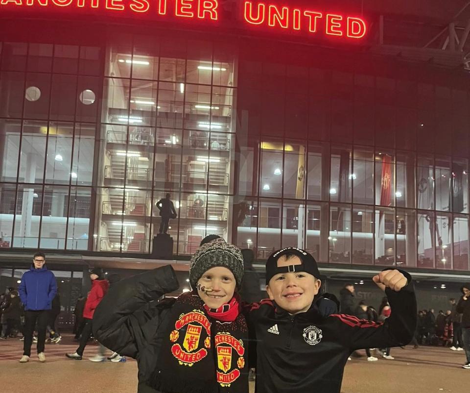 Two boys standing next to each other, flexing their muscles