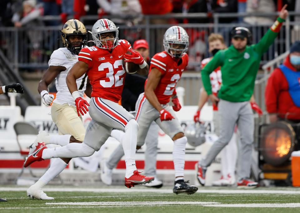 Ohio State Buckeyes running back TreVeyon Henderson (32) races up the sideline for a touchdown during the first quarter of the NCAA football game at Ohio Stadium in Columbus on Saturday, Nov. 13, 2021. 