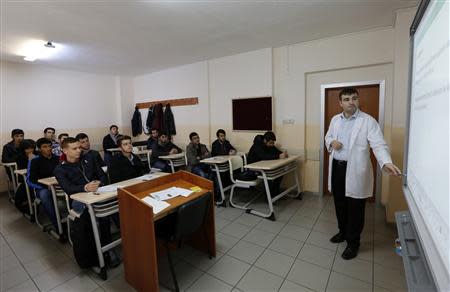 A teacher points to the board as he teaches students during a class at FEM University Preparation School in Uskudar November 27, 2013. REUTERS/Murad Sezer