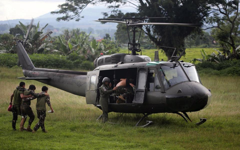 Wounded Filipino soldiers are carried onto a military helicopter following reports of fresh clashes between government troops and rebels in Marawi City, Mindanao Island, southern Philippines - Credit: LINUS G. ESCANDOR II/EPA