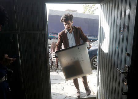 An Afghan election commission worker holds a ballot box at a polling station in Kabul, Afghanistan October 19, 2018. REUTERS/Omar Sobhani