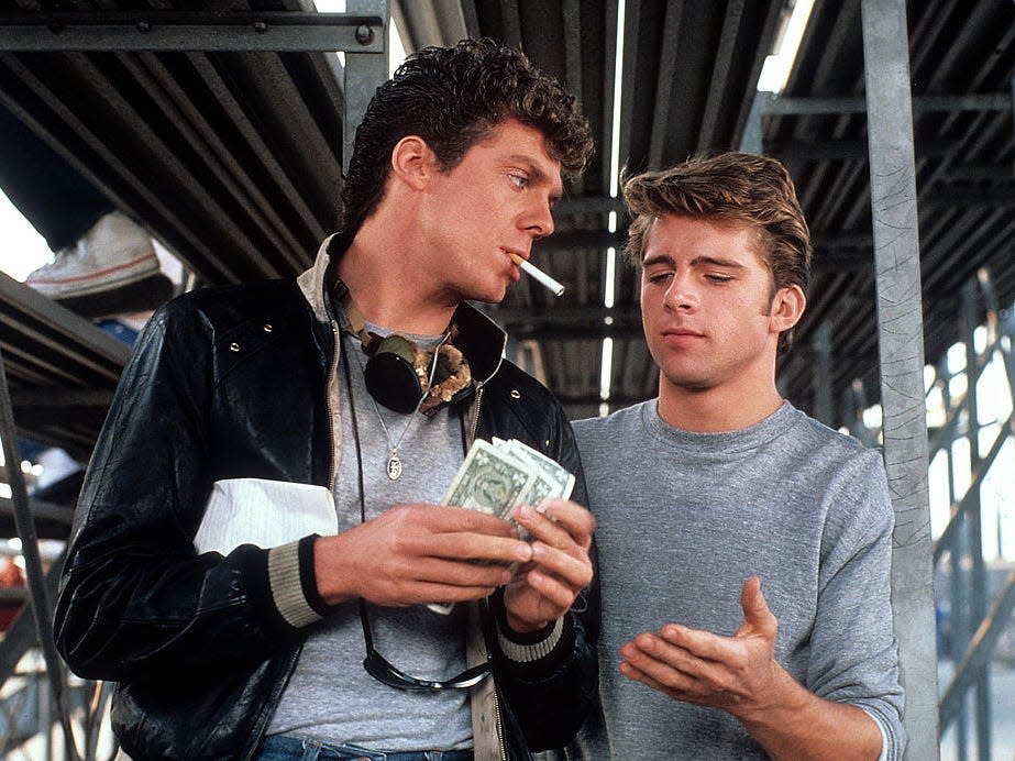 Grease 2 actors underneath the bleachers smoking cigarettes