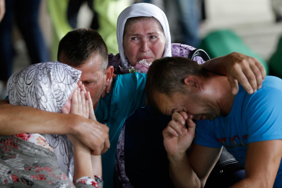 <p>People cry by the coffin of a relative, among 71 coffins displayed at the memorial centre of Potocari near Srebrenica, 150 kms north east of Sarajevo, in Bosnia, Sunday, July 9, 2017, where the newly identified victims of Europe’s worst massacre since World War II will be buried on the 22th anniversary of the crime on Tuesday. (Photo: Amel Emric/AP) </p>