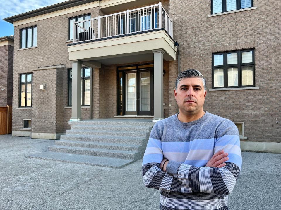 Paul Polyviou in the backyard of his home in Kleinburg, Ont. He hired Freedom Pools in May 2023 for what he says was supposed to be a two-week landscaping job. Almost a year later and after paying $72,000 in installments, the project remains unfinished. (Mark Boschler/CBC - image credit)