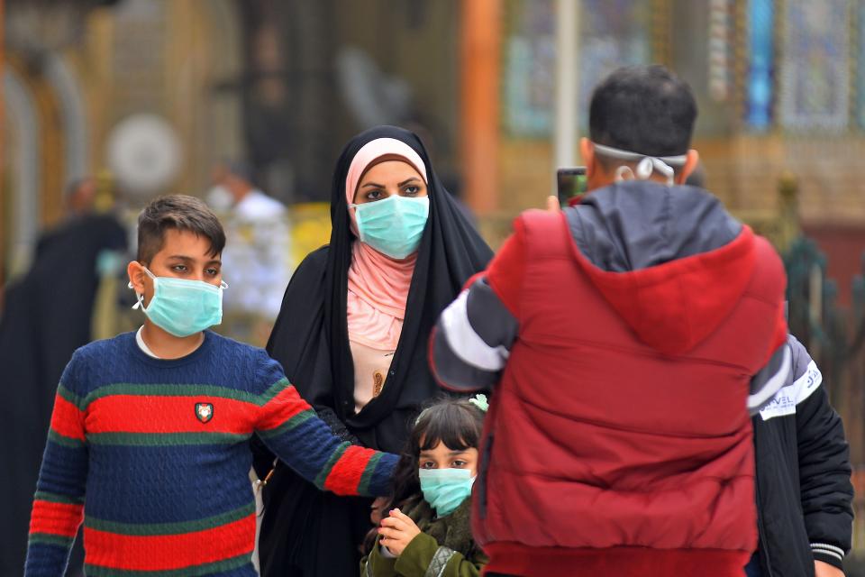 Iraqis wearing masks walk on February 25, 2020 in the partially deserted streets of Iraq's central shrine city of Najaf, where the first case of coronavirus COVID-19 has been documented in Iraq. - Iraq on February 24 confirmed its first novel coronavirus case in an elderly Iranian national in Najaf, according to health officials. A country with a dilapidated healthcare system, Iraq often hosts pilgrims and religious students from Iran, where at least a dozen people have died of the novel coronavirus since an outbreak there was first reported last week. Iraq had blocked travel to and from the Islamic republic days before announcing a seminary student in Najaf was the country's first confirmed case. (Photo by Haidar HAMDANI / AFP) (Photo by HAIDAR HAMDANI/AFP via Getty Images)