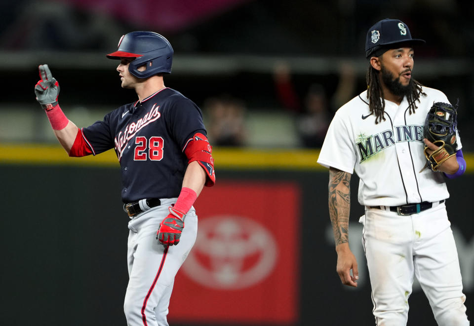 Washington Nationals' Lane Thomas celebrates his two-run double next to Seattle Mariners shortstop J.P. Crawford during the 11th inning of a baseball game Tuesday, June 27, 2023, in Seattle. The Nationals won 7-4. (AP Photo/Lindsey Wasson)