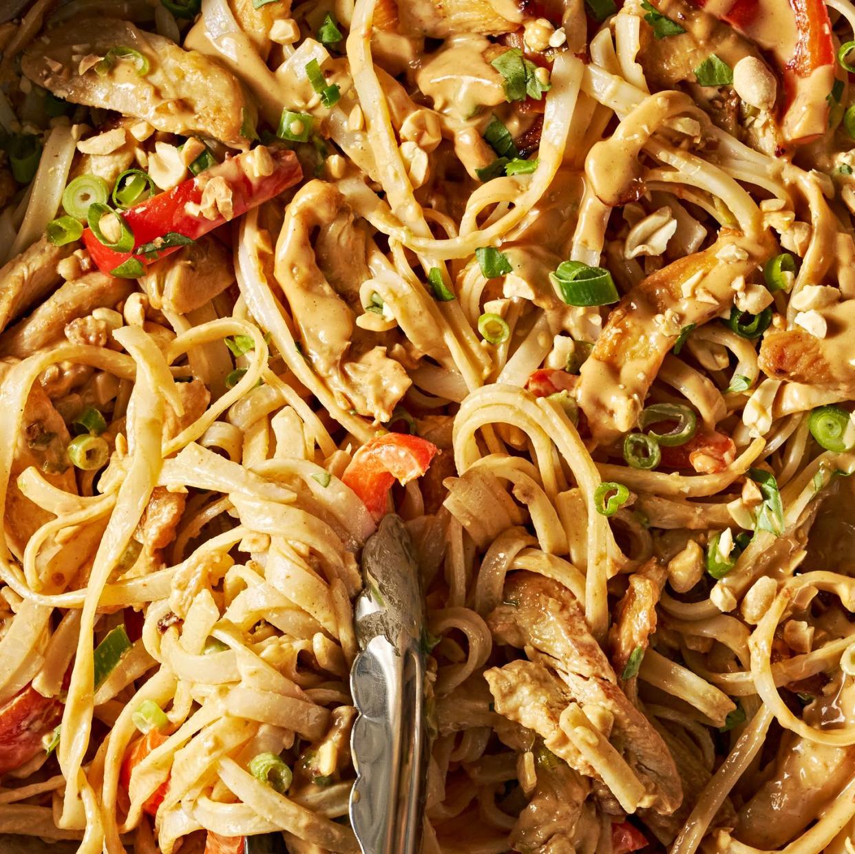 chicken with noodles and carrots in a creamy peanut lime sauce topped with peanuts