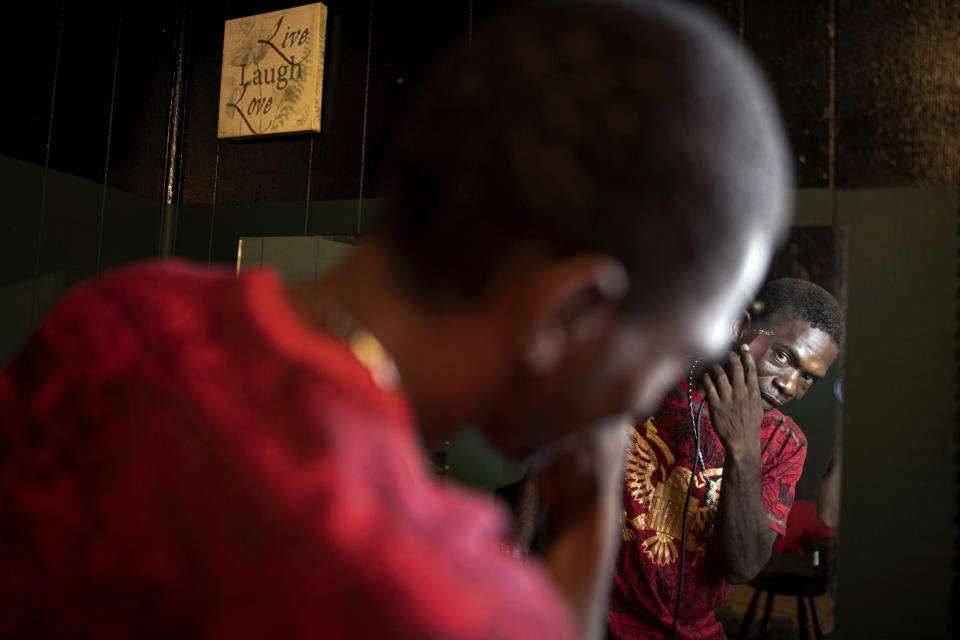 Joshua K. Love trims his hair in the living room of his home in Greenwood, Miss., Saturday, June 8, 2019. Love supports himself by giving discount haircuts to friends and family members. (AP Photo/Wong Maye-E)