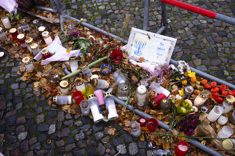 Candles, flowers and a letter reading 'You belong to us' lay at a barrier near the entrance of the building complex of the Kahal Adass Jisroel community, which houses a synagogue, a kindergarten and a community center, in the center of Berlin, Germany, Wednesday, Nov. 8, 2023. The complex in the city's Mitte neighbourhood was attacked with two incendiary devices on Oct. 18, 2023. (AP Photo/Markus Schreiber)