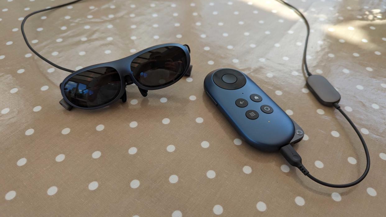  The Rokid Max AR glasses connected to the Rokid Station via a cable while they sit on a polka dot covered table. 