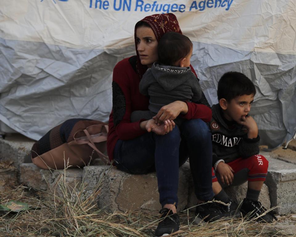 <span class="caption">A Syrian woman and her children await a tent and food near Mosul, Iraq on Oct. 17, 2019 after being driven from Syria. Refugees such as these children are likely to experience PTSD symptoms because of scarcity and being driven from their homes.</span> <span class="attribution"><a class="link " href="http://www.apimages.com/metadata/Index/APTOPIX-Iraq-Syria/6602f2b3d70e40168c553f25a05fb120/3/0" rel="nofollow noopener" target="_blank" data-ylk="slk:Hussein Malla/AP Photo;elm:context_link;itc:0;sec:content-canvas">Hussein Malla/AP Photo</a></span>