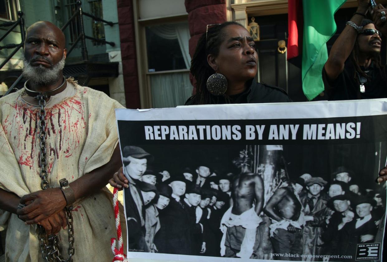 <span class="caption">Activists mark National Reparations Day in Washington, D.C., on July 1, 2019.</span> <span class="attribution"><a class="link " href="https://www.gettyimages.com/detail/news-photo/activists-stage-a-protest-to-mark-the-national-reparations-news-photo/1159502247?adppopup=true" rel="nofollow noopener" target="_blank" data-ylk="slk:Alex Wong/Getty Images;elm:context_link;itc:0;sec:content-canvas">Alex Wong/Getty Images</a></span>