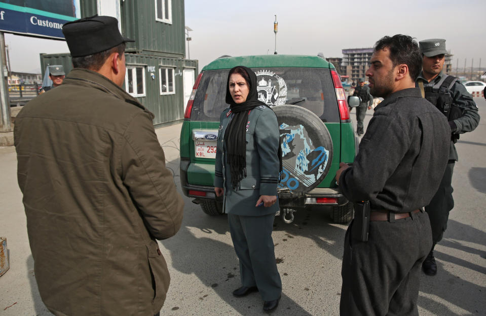 Afghanistan's first-ever female district police chief, Col. Jamila Bayaz, 50, center, talks to police at a check point in Kabul, Afghanistan, Thursday, Jan. 16, 2014. Afghanistan's first-ever female district police chief drew stares on Thursday as she drove and walked around the center of the city, reviewing check points and some of the important business and administrative facilities she is tasked with protecting. (AP Photo/Massoud Hossaini)
