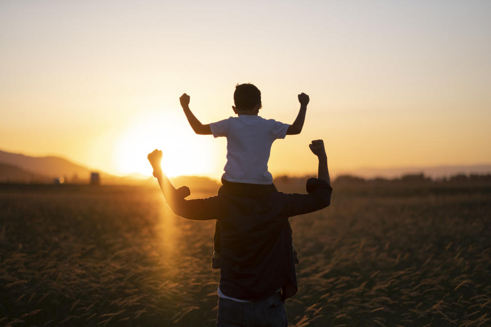 A father carrying his son on his shoulders