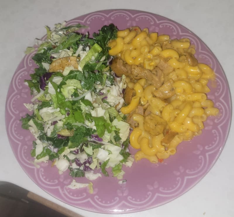 Salad and mac and cheese on a plate.
