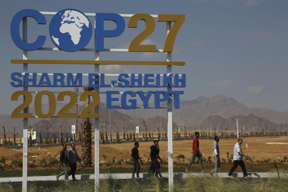 Workers walk past signage promoting this year’s United Nations global summit on climate change, known as COP27, adorns Peace Road, in Sharm el-Sheikh, South Sinai, Egypt, Wednesday, Nov. 2, 2022. As this year’s United Nations climate summit approaches, Egypt’s government is touting its efforts to make Sharm el-Sheikh a more eco-friendly tourist destination. (AP Photo/Thomas Hartwell)