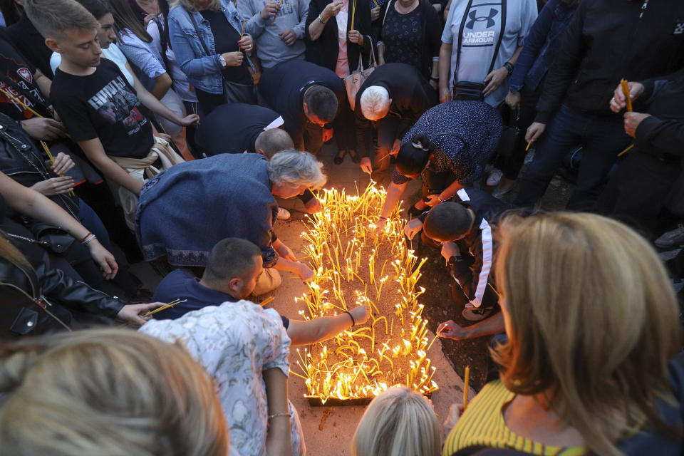 People light candles for the three killed Serbs in northern Serb-dominated part of ethnically divided town of Mitrovica, Kosovo, Tuesday, Sept.26, 2023. A Kosovo Serb party proclaimed three days of mourning starting Tuesday in Serb-dominated northern Kosovo for the three killed Serb assailants. Serbia's president demanded Tuesday to have a NATO-led peacekeeping force take over for the national law enforcement agency in northern Kosovo after a daylong shootout between armed Serbs and Kosovar police left one officer and three gunmen dead. (AP Photo/Bojan Slavkovic)