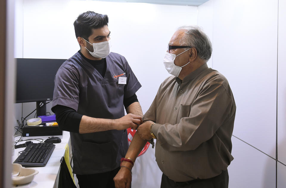 Aneet Kapoor, a pharmacist from Manchester, got to vaccinate his 79-year-old dad, Suneel, who has been shielding during lockdown (MCC)