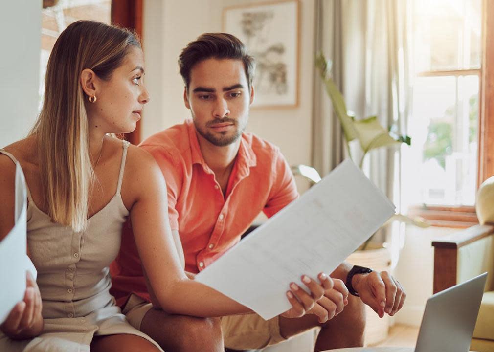 A couple looking at financial documents having a discussion.