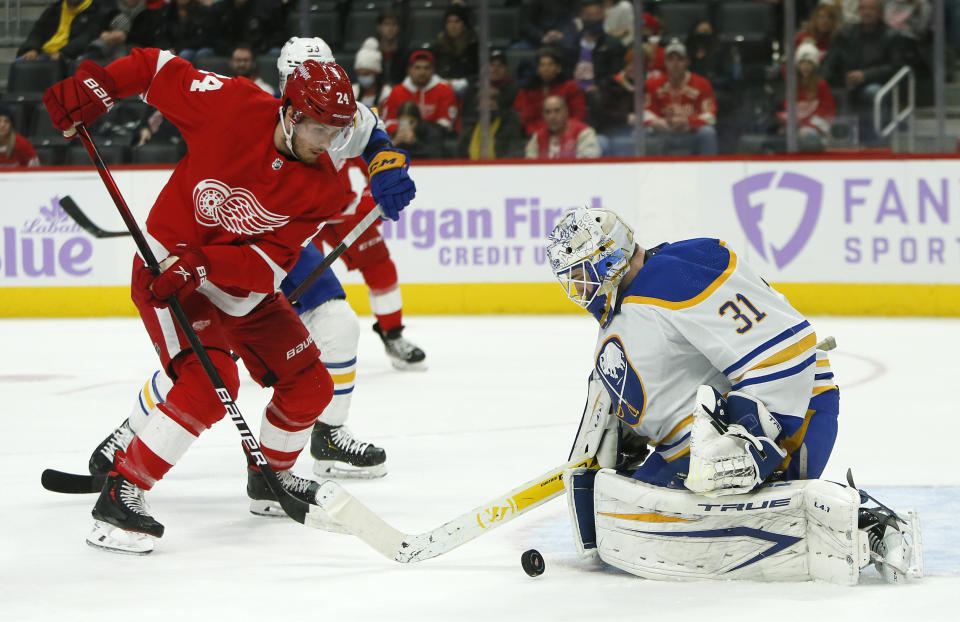 Buffalo Sabres goaltender Dustin Tokarski (31) deflects a shot by Detroit Red Wings center Pius Suter (24) during the first period of an NHL hockey game Saturday, Nov. 27, 2021, in Detroit. (AP Photo/Duane Burleson)