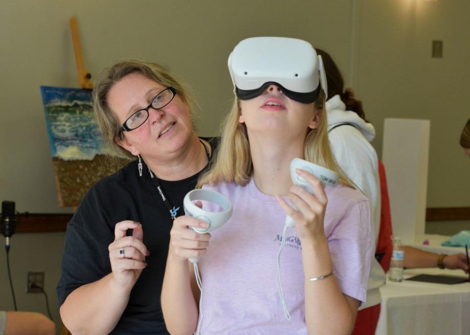 Heidi Troyer, left, an employee specialist with Ottawa County Jobs & Family Services, shows a student who to use virtual reality gear. Students could utilize the equipment to watch a simulated children services investigation or to learn a skilled trade.