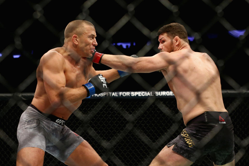 Michael Bisping (R) and Georges St-Pierre trade punches during their middleweight championship bout at UFC 217. (Getty)