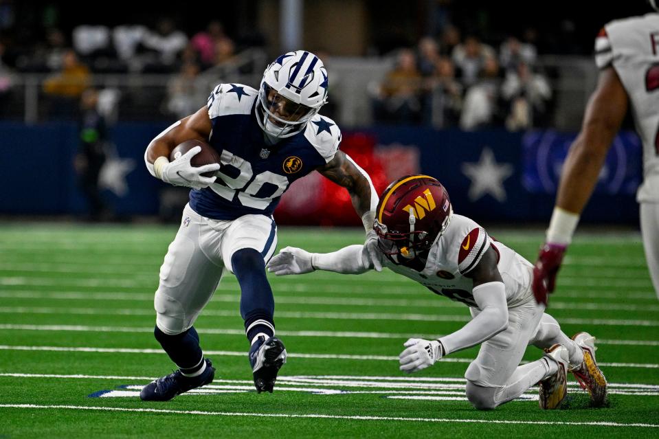 Dallas Cowboys running back Tony Pollard and Washington Commanders safety Jartavius Martin in action during the game between the Dallas Cowboys and the Washington Commanders at AT&T Stadium.