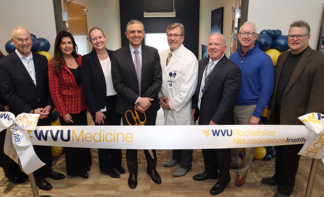 Officials cut the ribbon for the new, expanded clinic in the WVU Medicine Spring Mills Medical Office Building on Jan. 8, 2024. Left to right: Dr. Clay Marsh, chancellor and executive dean, West Virginia University Health Sciences; Elizabeth Webster, president and CEO, Martinsburg-Berkeley County Chamber of Commerce; Karyn Wallace, vice president of neuroscience, WVU Rockefeller Neuroscience Institute (RNI); Dr. Ali Rezai, RNI executive chair and director; Dr. John Caruso, chief of neurosurgery, WVU Medicine Berkeley Medical Center; Dean Thomas, president and CEO, Berkeley Medical Center and Jefferson Medical Center; Jeff Boehm, president, Howard Shockey & Sons Inc; and architect Matthew Grove with Grove & Dall'Olio Architects.