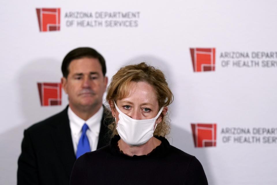 FILE - In this Wednesday, Dec. 2, 2020 file photo Arizona Department of Health Services Director Dr. Cara Christ speaks as Republican Arizona Gov. Doug Ducey listens during a news conference, in Phoenix. Arizona expects to get enough doses of a new coronavirus vaccine by the end of the year to inoculate more than 383,000 health care workers and long-term care facility residents, Dr. Christ said Friday, Dec. 4, 2020. (AP Photo/Ross D. Franklin, Pool, File)