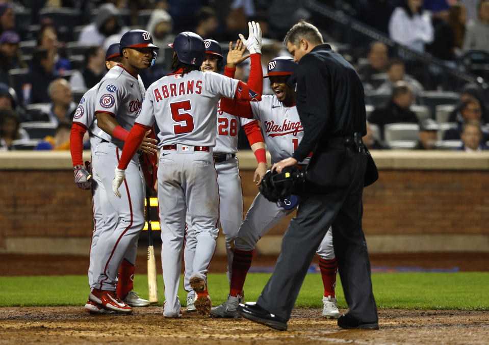 Washington Nationals' CJ Abrams (5) celebrates with teammates after hitting a grand slam against the New York Mets during the eighth inning of a baseball game Thursday, April 27, 2023, in New York. (AP Photo/Noah K. Murray)