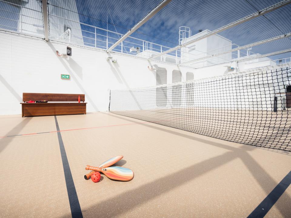 empty pickleball court with paddles on ground