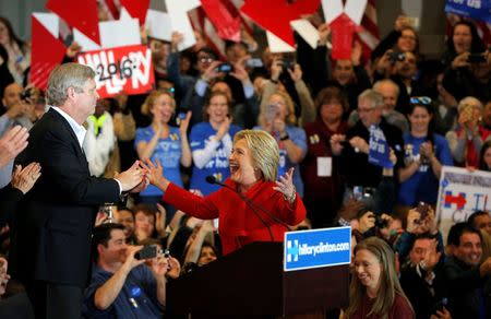 Democratic U.S. presidential candidate Hillary Clinton (R) celebrates with United States Secretary of Agriculture Tom Vilsack (L) at her caucus night rally in Des Moines, Iowa February 1, 2016. REUTERS/Brian Snyder