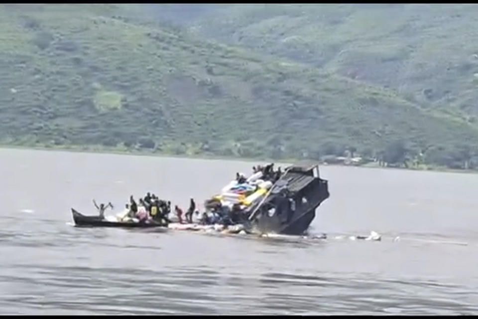 In this video frame grab, a boat sinks in the Congo river outside Kinshasa, Democratic republic of the Congo, Monday, Feb. 12, 2024. A local official in Congo says dozens of people are dead and several are missing after two boats collided on the Congo River. The official says the boats loaded with people and goods. (AP Photo)